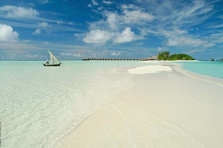 island with boat at Cocoa Island by COMO Resort Maldives