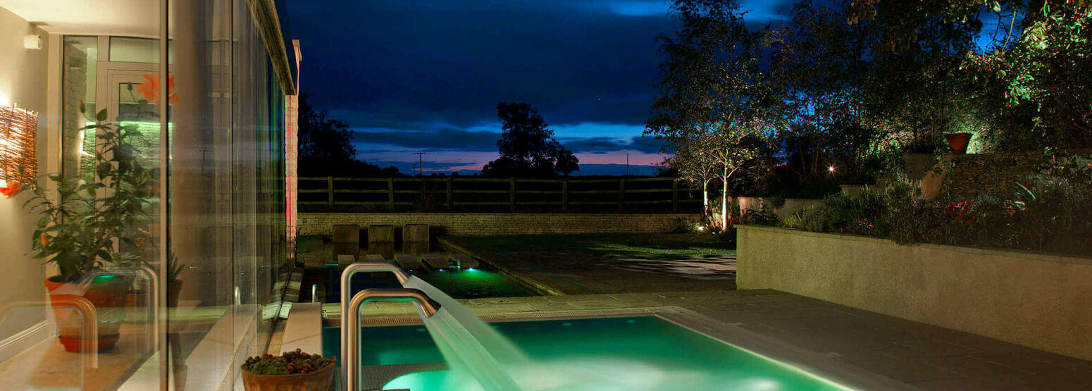 Side shot of hydrotherapy pool at night at barnsley house england uk