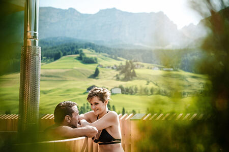 Hot tub and views across meadow and mountains at Hotel La Majun Italy