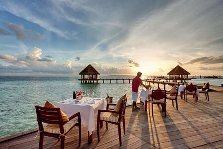 Dining tables in front of Matheefaru Sunset at Hideaway Beach Resort Maldives