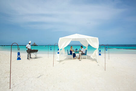 A couple dining on the beach at reethi beach resort maldives