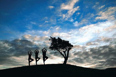 Three people practising yoga against the sky at Six Senses Douro Valley Portugal