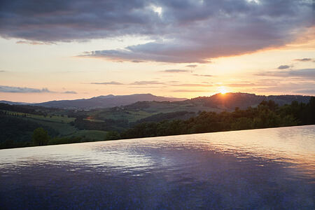 Infinity pool at sunset at Castello di Casole Italy
