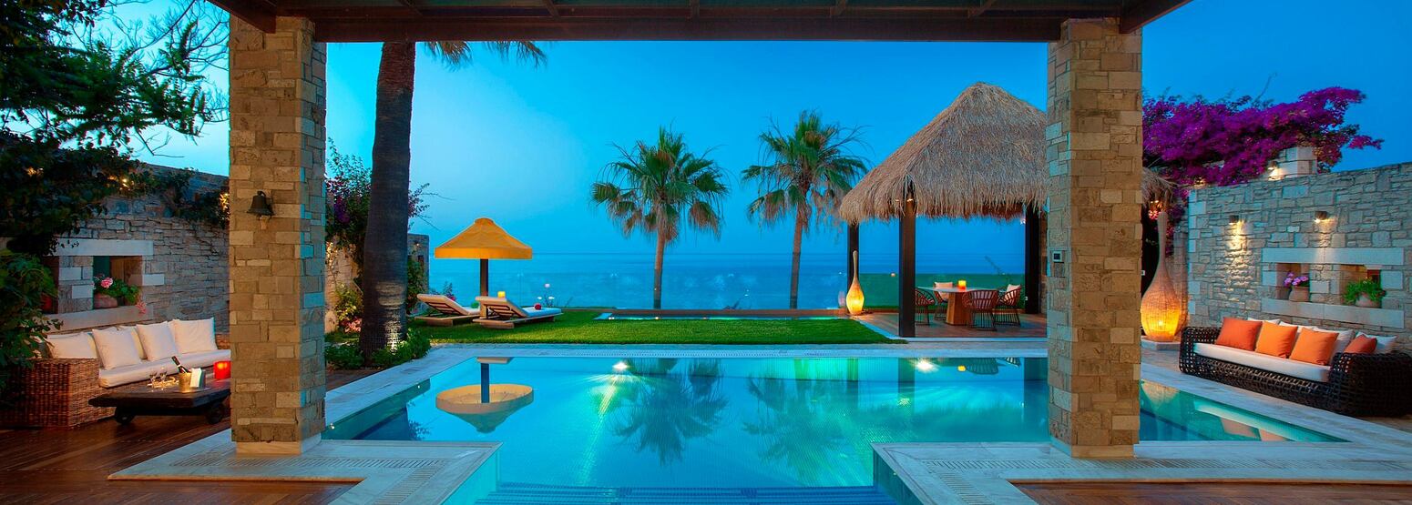 Outdoor decking and pool area of a royal spa villa at dusk
