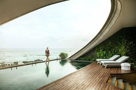 Women walking at the edge of pool with views out to the ocean at COMO Canggu