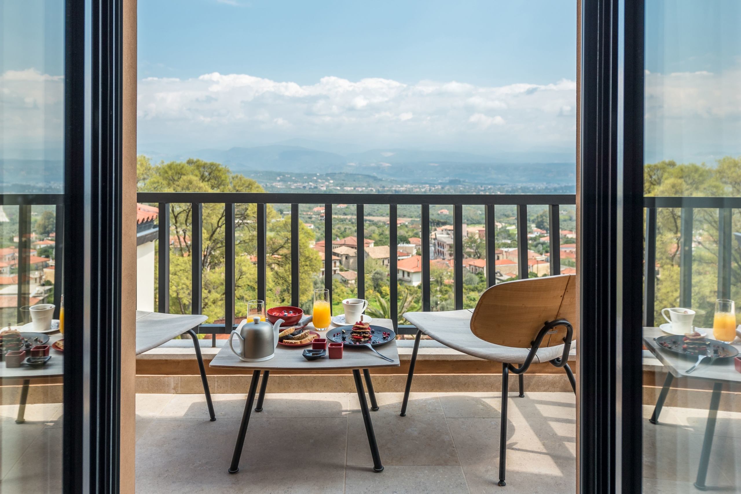 Breakfast being served on a balcony overlooking the Greek countryside