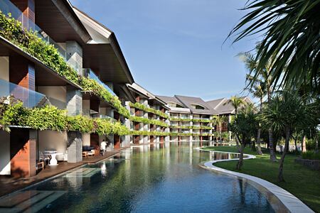 Exterior of COMO Canggu Bali featuring rooms, swimming pool and palm trees
