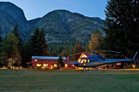 The lodge at night with helicopter at Tweedsmuir Park Lodge Canada
