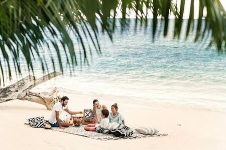 Family on the beach Four Seasons Desroches Island Seychelles